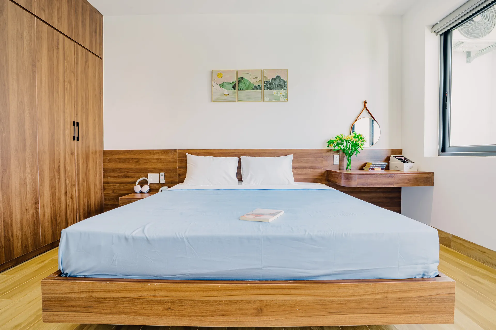 A bright bedroom with a balcony door and a sofa along the wall.